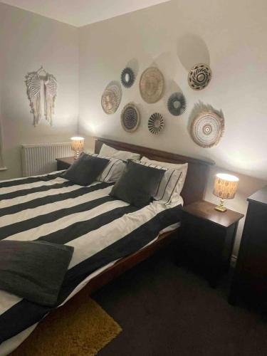 a bedroom with a large bed with plates on the wall at Large town centre apartment with parking in Wallingford