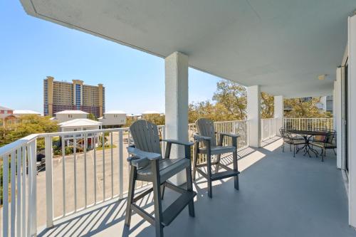a balcony with three chairs and a table on it at Compass Point 310 in Gulf Shores