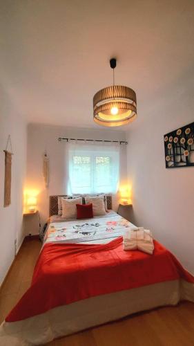 a bedroom with a large bed with a red blanket at Casinha CB in Casteição