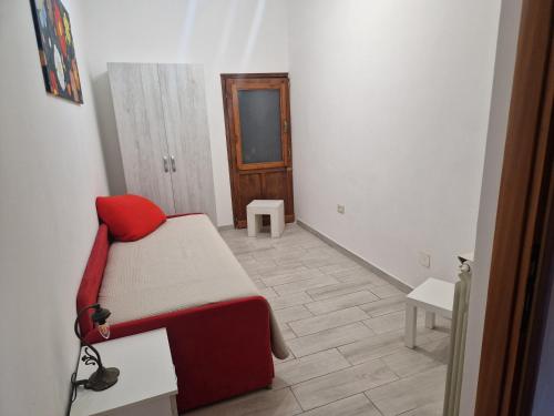 a small room with a bed with a red pillow at Alla Fonte in Massa dʼAlbe