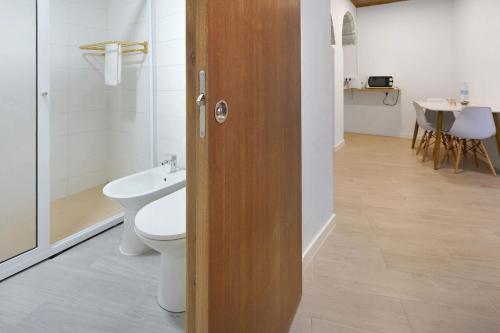 a bathroom with a toilet and a sink at Casa Flor de Laranjeira in Faial da Terra