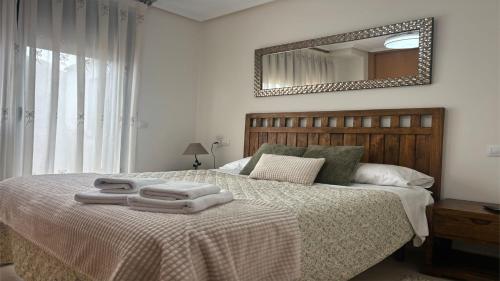 a bedroom with a bed with two towels on it at PISO AINETXA in Posada de Llanes