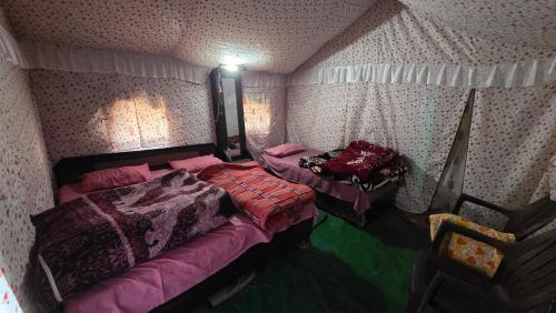 a bedroom with two beds in a room at Lord Shiva Camps in Sari