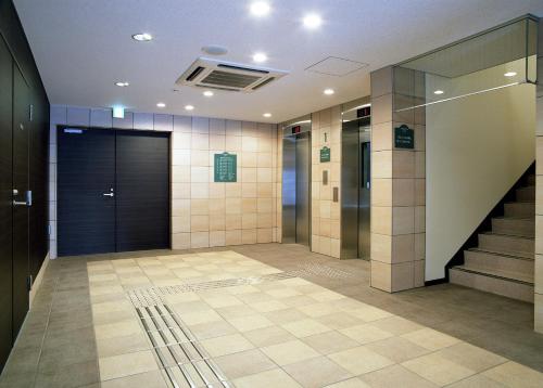 a lobby with elevators and a staircase in a building at Sotetsu Fresa Inn Fujisawa Shonandai in Fujisawa