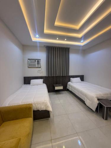 a hotel room with two beds and a couch at درة القيم in Taif
