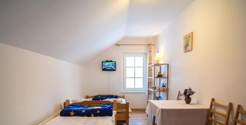 シュクラルスカ・ポレンバにあるGosciniec Poezjaのベッド3台、テーブル、窓が備わる客室です。