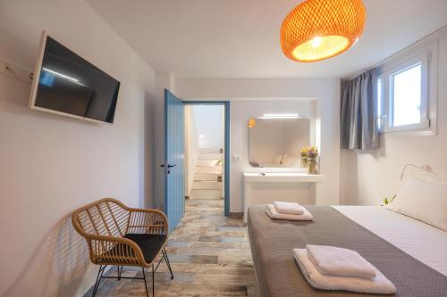 a bedroom with a bed and a chair and a bathroom at Depis luxury private villas in Plaka