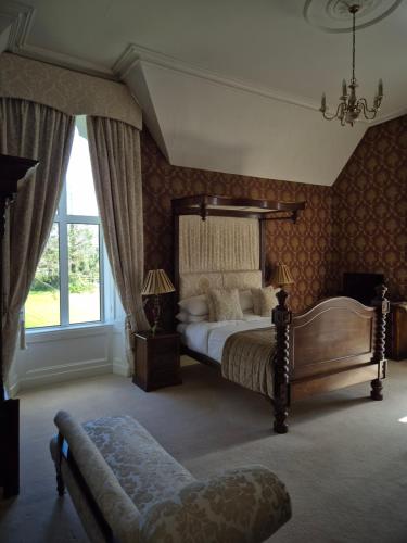 a bedroom with a bed and a large window at Glenduff Manor in Glendiff