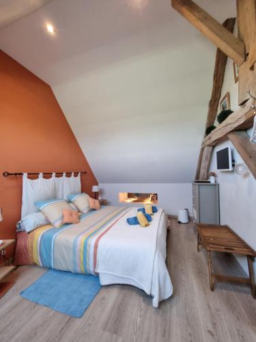 a bedroom with a large bed and a wooden floor at Chambres d'Hôtes du Paillé in Thenay