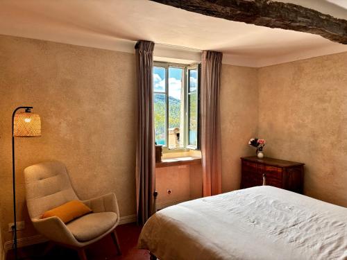 a bedroom with a bed and a chair and a window at Vue Lac avec Terrasse Privée - "Lani" - Ola Verdon in Bauduen