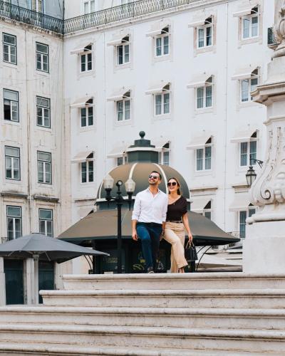 a man and a woman sitting on top of some stairs at AlmaLusa Baixa/Chiado in Lisbon