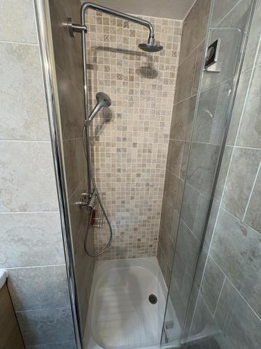 a shower with a glass door in a bathroom at Superbe studio terrasse piscine et plage in Fréjus