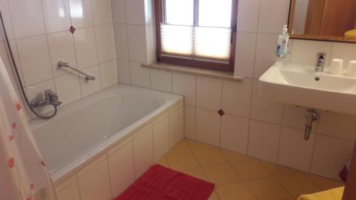 ein Badezimmer mit einer Badewanne und einem Waschbecken in der Unterkunft Riegergut in Unken