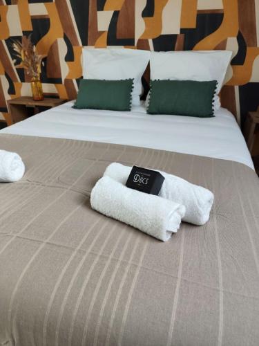 a bed with two towels on top of it at l'imprimerie in Malestroit