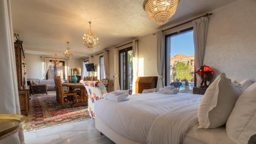a bedroom with a large bed and a living room at Villa Thaifa & SPA in Marrakesh
