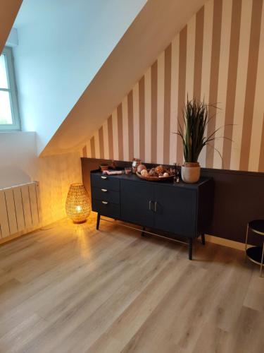 a room with a black dresser and a staircase at l'imprimerie in Malestroit
