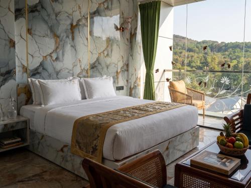 a bedroom with a large bed and a large window at Majestic Marvel in Maraiyūr