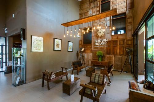 a lobby of a building with a clock on the wall at Brown House Hotel in Udon Thani