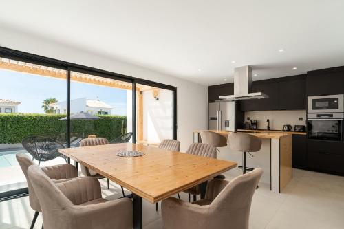 a kitchen and dining room with a wooden table and chairs at Casablanca Exclusive Villa - Private Pool & BBQ in Albufeira