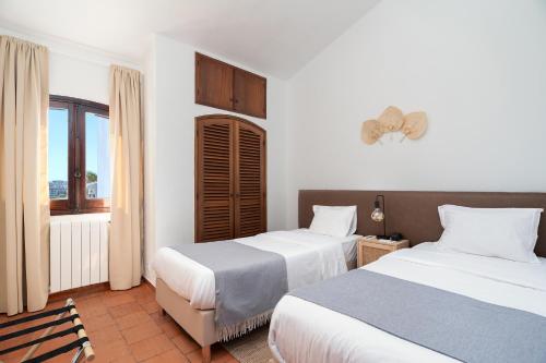 a hotel room with two beds and a window at Casablanca Exclusive Villa - Private Pool & BBQ in Albufeira
