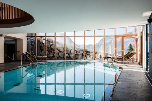 a hotel pool with a view of mountains at Hotel Goldener Berg in Lech am Arlberg