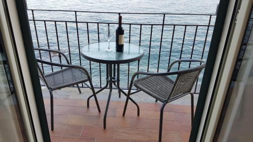 - une table avec une bouteille de vin et 2 chaises sur un balcon dans l'établissement Loft Profumo di Mare, à Giardini Naxos