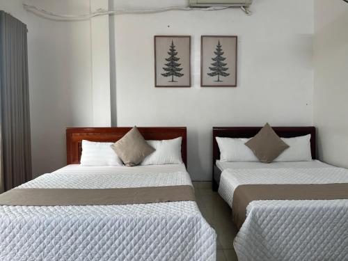two beds sitting next to each other in a room at An Phú Stay & Coffee in Cửa Lô
