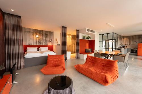 a bedroom with a bed and two orange chairs at ORANGE LOUNGE Attersee in Weyregg