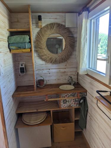 a bathroom with a sink and a mirror at Tiny chouette et jacuzzi in Doulezon