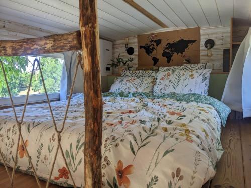 a bed with a floral comforter in a room at Tiny chouette et jacuzzi in Doulezon