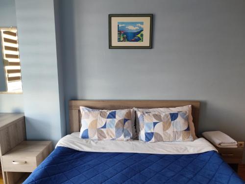 a bed with blue sheets and pillows in a bedroom at Apartment Temple in Podgorica