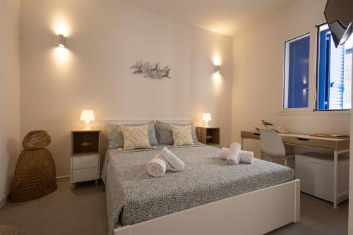 a bedroom with a bed with towels on it at Montebello Room's in Marettimo