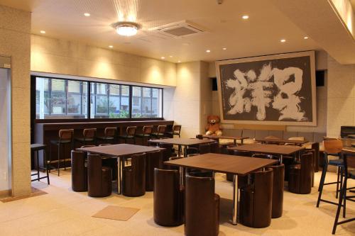 a restaurant with tables and chairs and a painting on the wall at Art Five Hotel BOIS博多 in Fukuoka