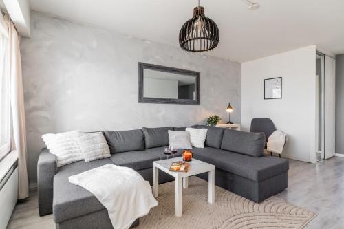 a living room with a gray couch and a table at Nordic Nook By Elys Collection in Rovaniemi