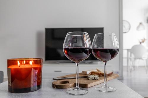 two glasses of red wine and a candle on a table at Nordic Nook By Elys Collection in Rovaniemi