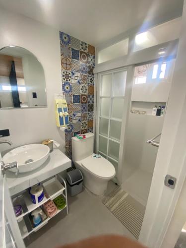 a bathroom with a toilet and a sink and a shower at Balai Mi Vigan in Vigan