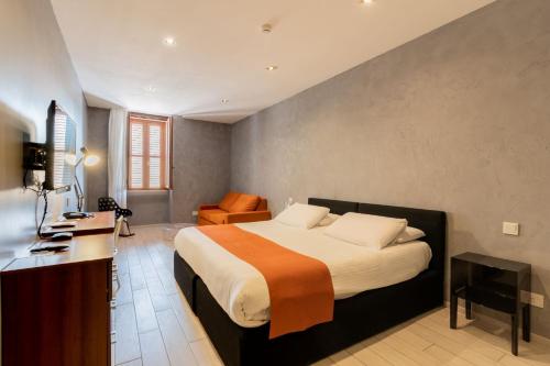 a bedroom with a bed and a desk in a room at Quaint Boutique Hotel Sannat in Sannat