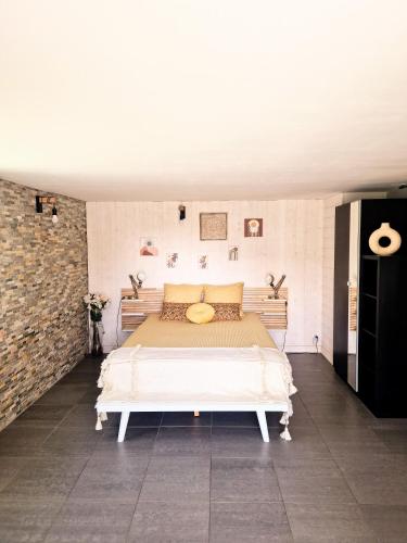 a bedroom with a large bed in a brick wall at Villa Océan Labenne Plage in Labenne