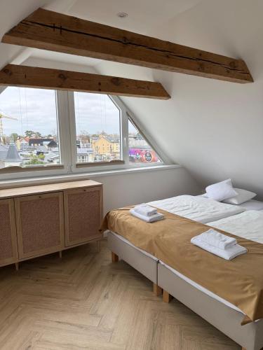 a bedroom with two beds and a large window at Enklawa - Floryn Mielno in Mielno