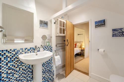 a bathroom with a white sink and a blue and white tiles at 1 Bed in Evesham oc-55177 in Bretforton