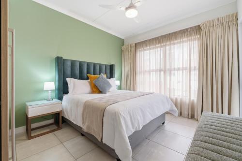 a bedroom with a large bed and a window at Ballito Hills 171 in Ballito
