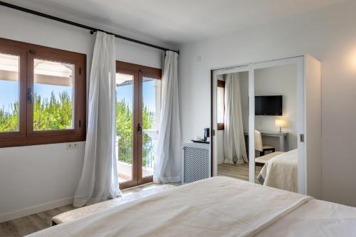 a bedroom with a bed and a large mirror at Hoposa Bahia in Port de Pollensa