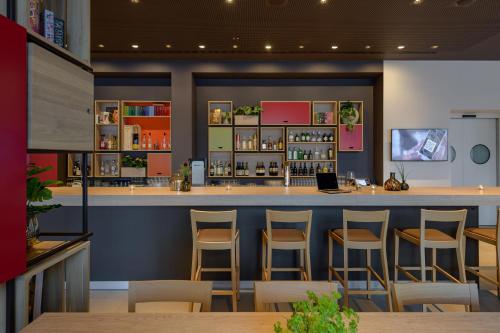 a bar in a restaurant with stools at IntercityHotel Herford in Herford