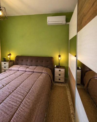 a bedroom with a bed and a green wall at Il nido in Cecina
