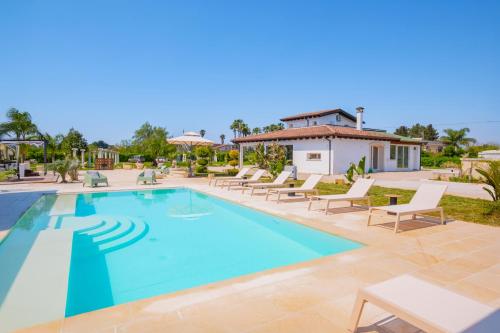 a swimming pool with lounge chairs and a house at Villa Kalia Luxury by HDSalento in Aradeo