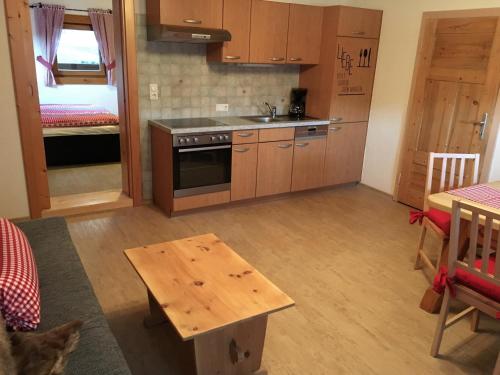a kitchen with wooden cabinets and a table in a room at Untersteinhof in Mittersill