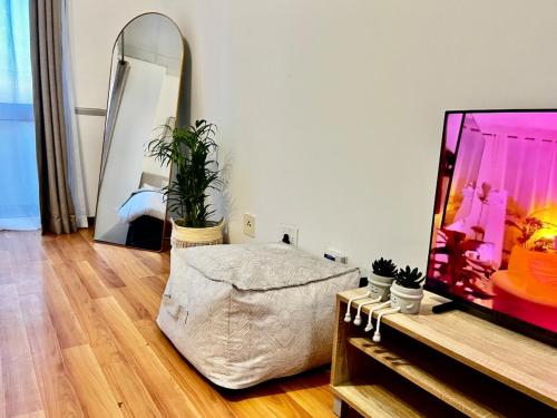 a living room with a tv and a mirror at High Rise Haven 2 in Johannesburg