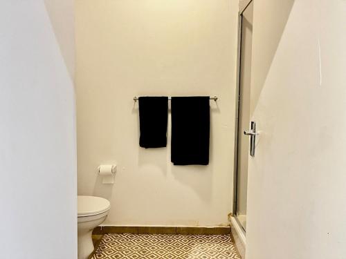 a bathroom with a toilet and two black towels at High Rise Haven 2 in Johannesburg