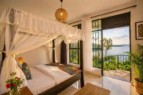 a bedroom with a canopy bed and a large window at Kaliba Beach - Rutsiro in Rutsiro