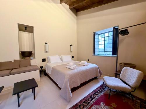 a bedroom with a bed and a couch and a window at Alfa25 in Oitylo